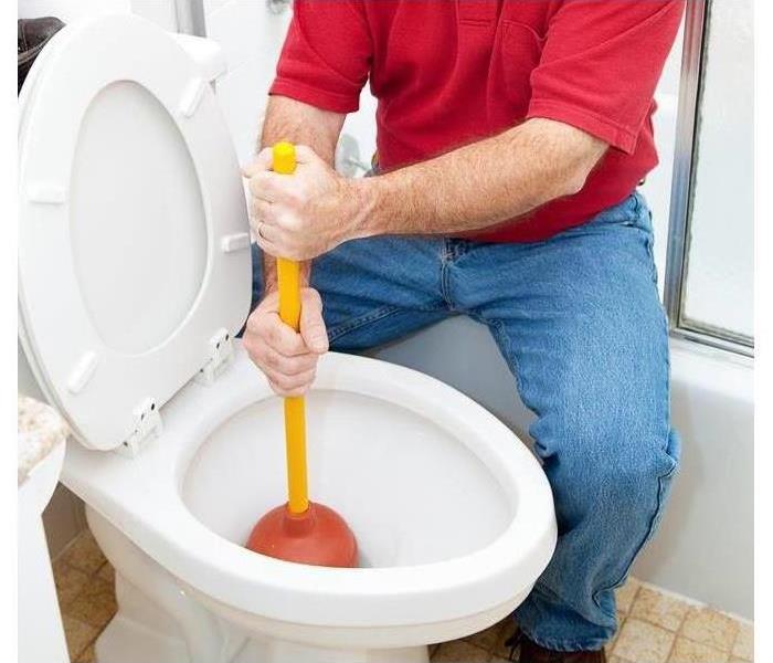 Worker plumbing toilet